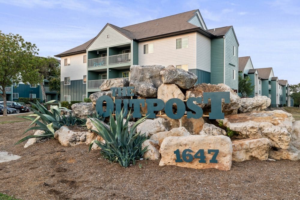 the outpost san marcos apartments near texas state university monument sign