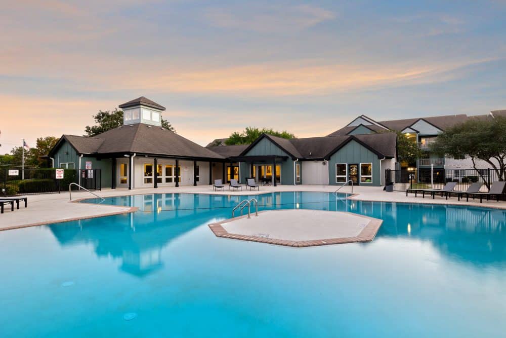 the outpost san marcos apartments near texas state university resort style pool clubhouse exterior sunset