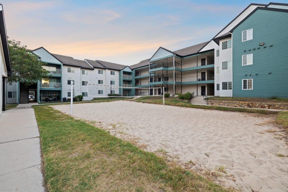 the outpost san marcos apartments near texas state university sand volleyball court building exterior